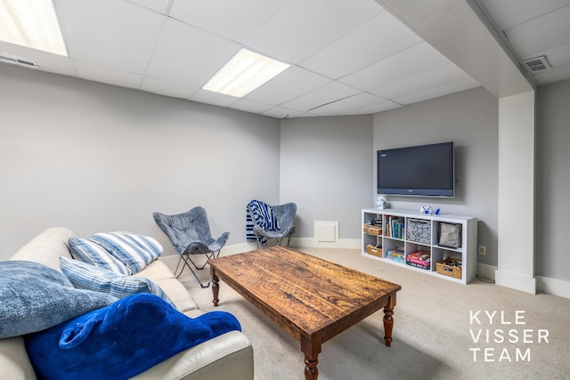 living room with a drop ceiling and carpet flooring