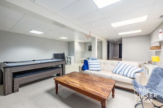 living room featuring light carpet and a paneled ceiling