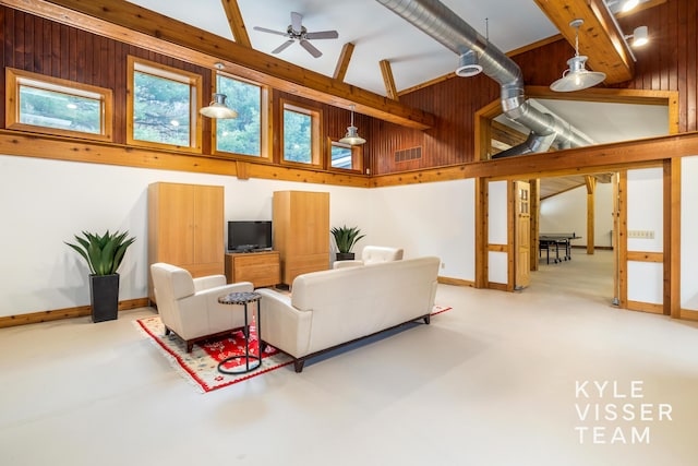 living room featuring ceiling fan, high vaulted ceiling, concrete floors, and wood walls