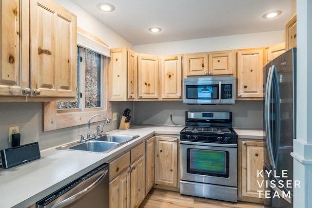 kitchen featuring sink, light brown cabinets, light hardwood / wood-style floors, and appliances with stainless steel finishes