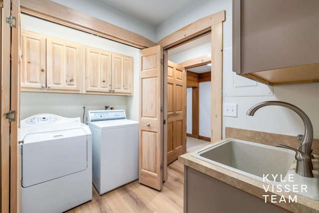 washroom featuring light hardwood / wood-style floors, cabinets, separate washer and dryer, and sink