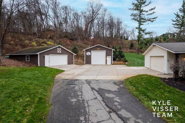 exterior space with an outbuilding, a garage, and a lawn