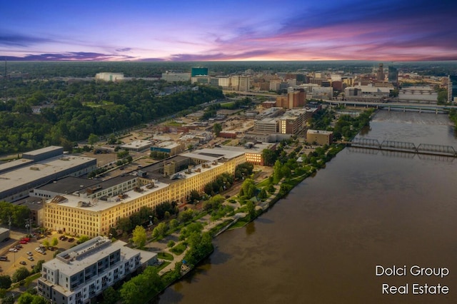 aerial view at dusk featuring a water view