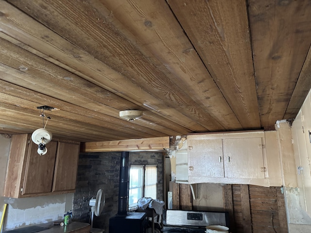 kitchen featuring hanging light fixtures, wood ceiling, range, and a wood stove