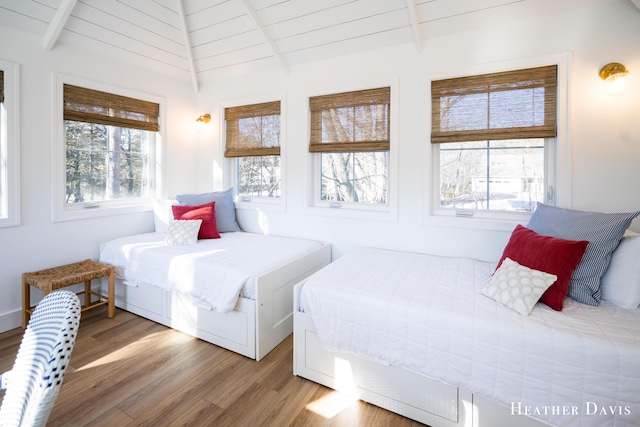 bedroom with hardwood / wood-style floors and lofted ceiling with beams