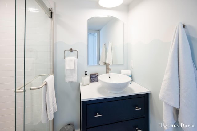 bathroom with a shower with door and vanity