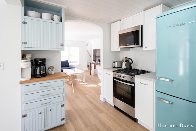 kitchen featuring butcher block counters, white cabinetry, tasteful backsplash, light hardwood / wood-style flooring, and stainless steel appliances