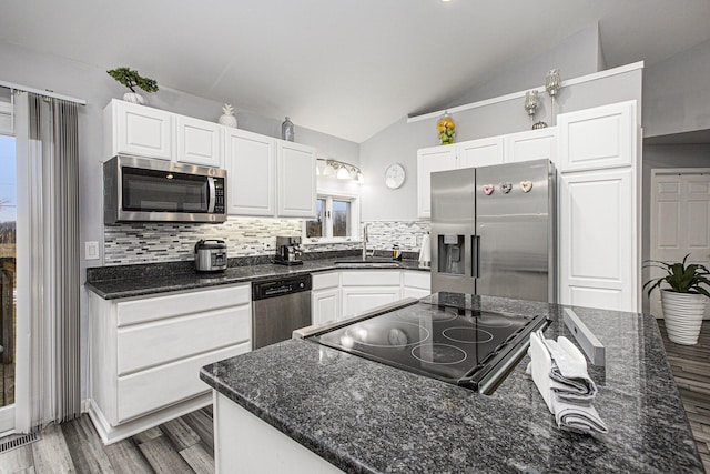 kitchen with white cabinetry, appliances with stainless steel finishes, sink, and lofted ceiling