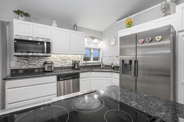 kitchen featuring sink, stainless steel appliances, tasteful backsplash, white cabinets, and vaulted ceiling