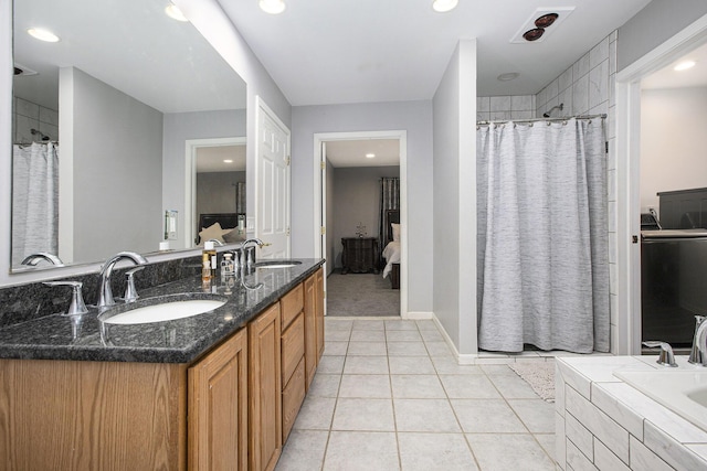 bathroom featuring a relaxing tiled tub, tile patterned floors, and vanity