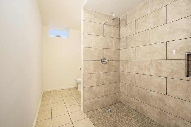 bathroom featuring tiled shower, toilet, and tile patterned flooring