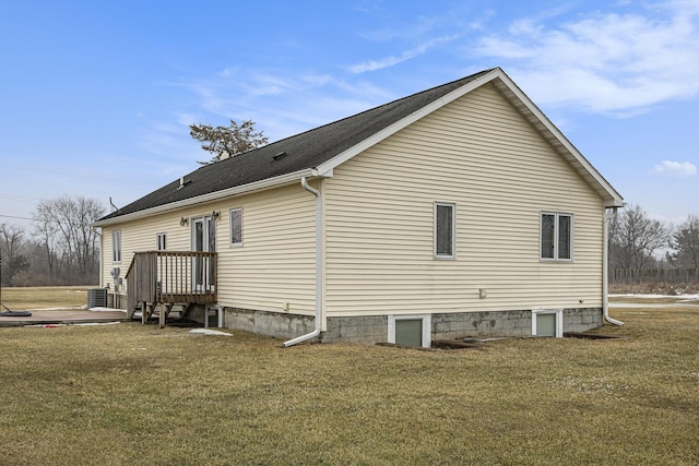 view of side of property with central AC and a yard