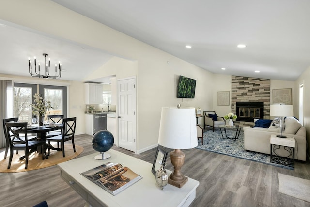 living room featuring wood-type flooring, lofted ceiling, and a fireplace