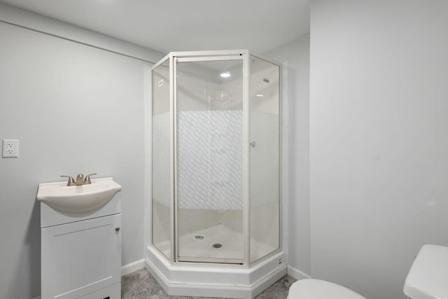 bathroom with vanity, a shower with door, and toilet