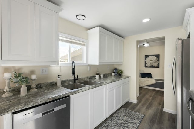 kitchen with sink, dark wood-type flooring, stainless steel appliances, and white cabinets