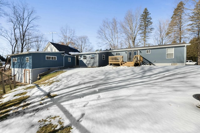 snow covered property featuring a deck