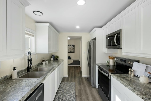 kitchen featuring appliances with stainless steel finishes, sink, white cabinets, and dark hardwood / wood-style floors