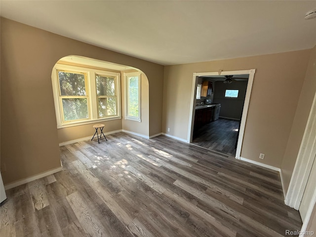 2372 E Boatfield Ave, Burton, MI 48529 - empty room featuring arched walkways, dark wood finished floors, and a smoke detector