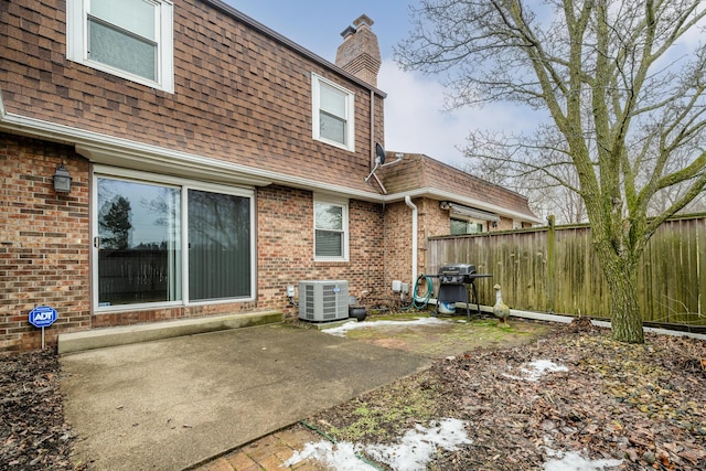 rear view of house featuring cooling unit and a patio