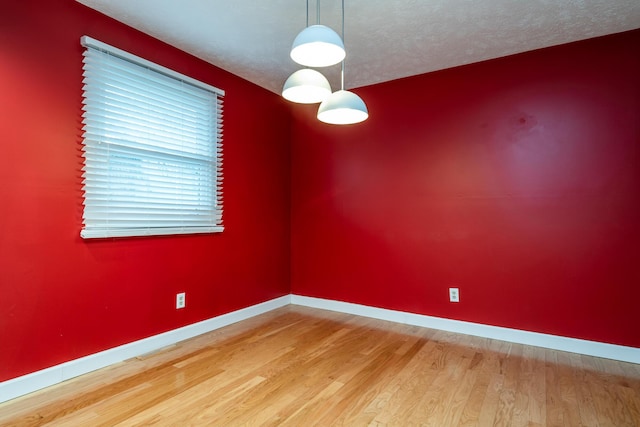 unfurnished room featuring hardwood / wood-style flooring and a textured ceiling