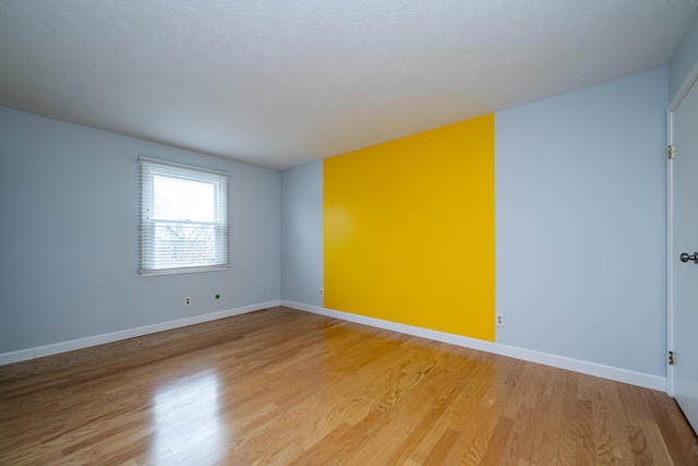 spare room with hardwood / wood-style floors and a textured ceiling