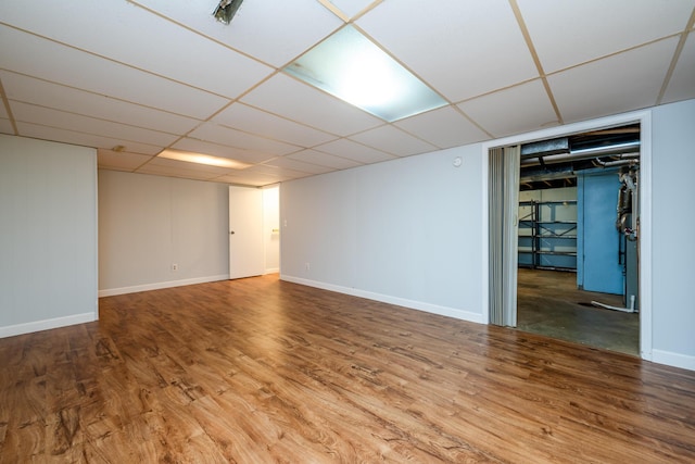 basement featuring hardwood / wood-style flooring and a paneled ceiling