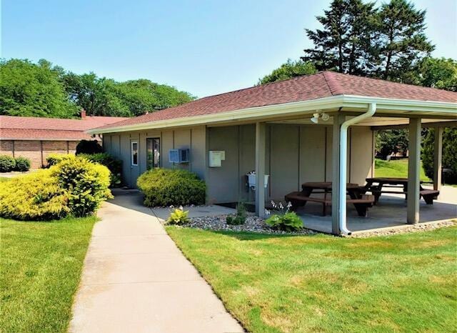 entrance to property featuring a patio area and a lawn