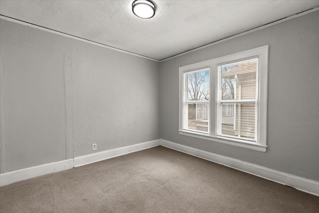 carpeted empty room featuring a textured ceiling