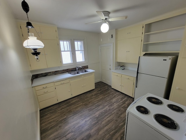 kitchen featuring sink, white appliances, dark wood-type flooring, ceiling fan, and hanging light fixtures