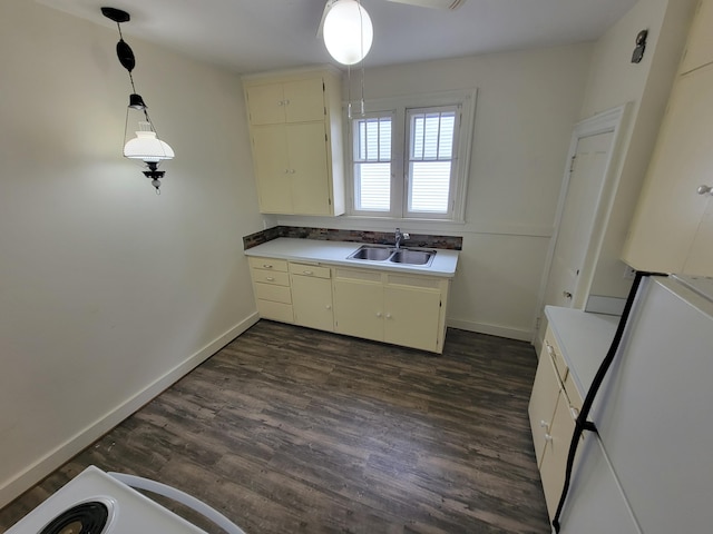 kitchen featuring white fridge, dark hardwood / wood-style flooring, sink, and hanging light fixtures