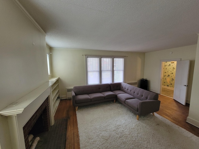 living room with ornamental molding, radiator heating unit, dark hardwood / wood-style flooring, and a textured ceiling