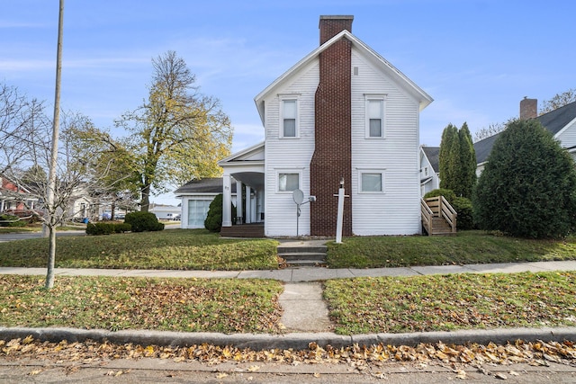 view of front property with a garage, covered porch, and a front lawn