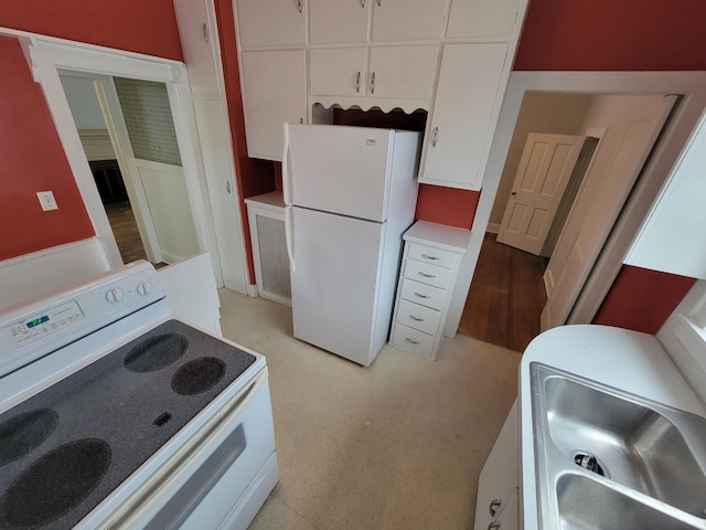 kitchen featuring white cabinets and white appliances