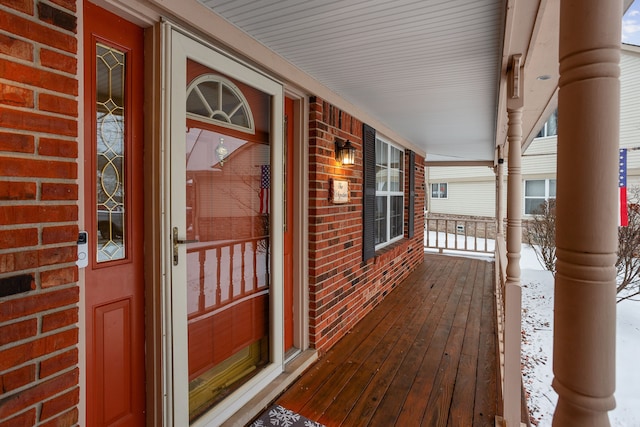 snow covered deck featuring a porch