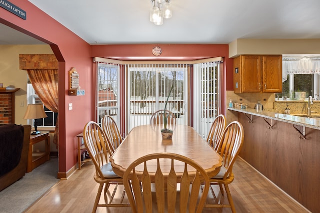 dining space with sink and light hardwood / wood-style flooring