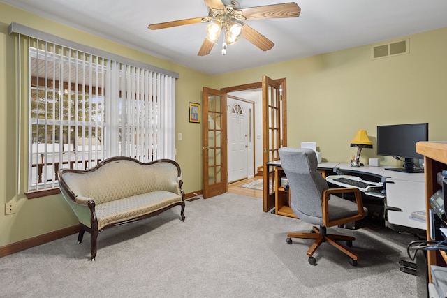 home office featuring light colored carpet, french doors, and ceiling fan