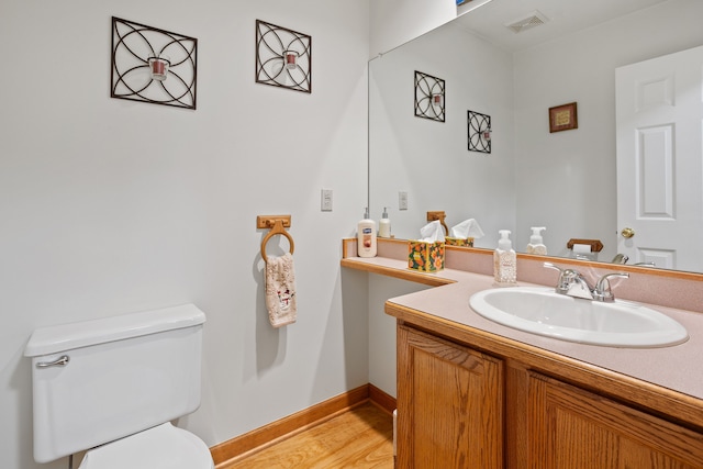 bathroom featuring vanity, hardwood / wood-style flooring, and toilet