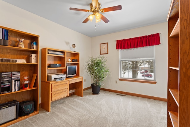 carpeted office space with ceiling fan