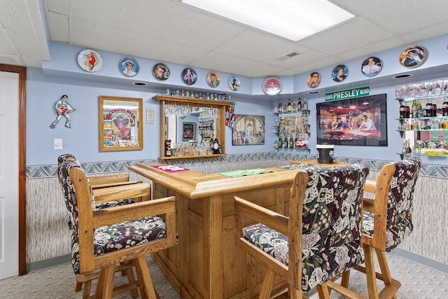 bar with a paneled ceiling and carpet