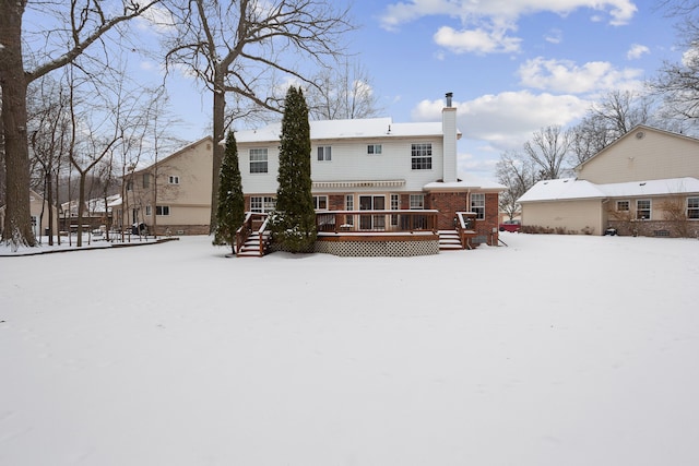 snow covered rear of property with a wooden deck