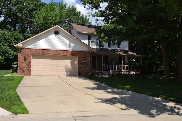 view of front of house featuring a garage, a front lawn, and covered porch