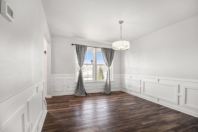 unfurnished dining area with dark hardwood / wood-style floors and a chandelier