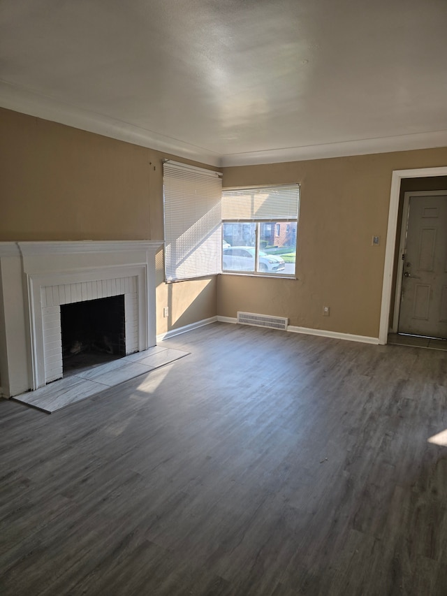 unfurnished living room with crown molding, hardwood / wood-style floors, and a brick fireplace