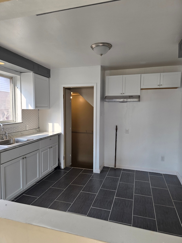 kitchen featuring white cabinetry, sink, and tasteful backsplash