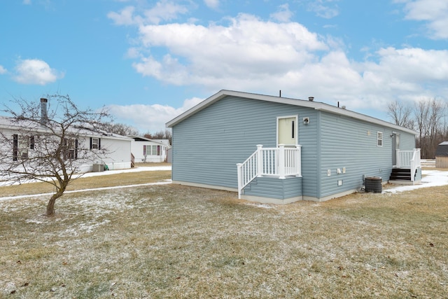 view of property exterior featuring central AC and a lawn