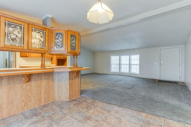 kitchen featuring decorative light fixtures, vaulted ceiling with beams, carpet floors, a breakfast bar area, and a textured ceiling