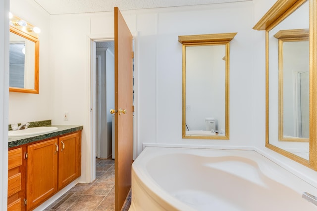 bathroom featuring vanity, toilet, and a washtub