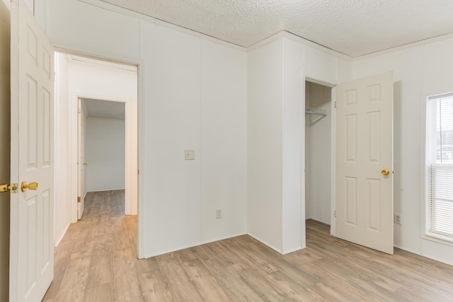 unfurnished bedroom featuring a textured ceiling and light wood-type flooring