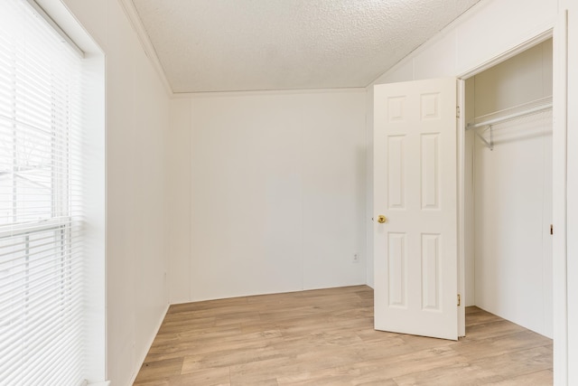 unfurnished bedroom featuring a closet, light hardwood / wood-style flooring, and a textured ceiling