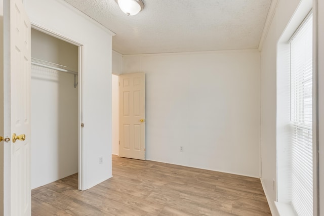 unfurnished bedroom with a closet, a textured ceiling, and light wood-type flooring